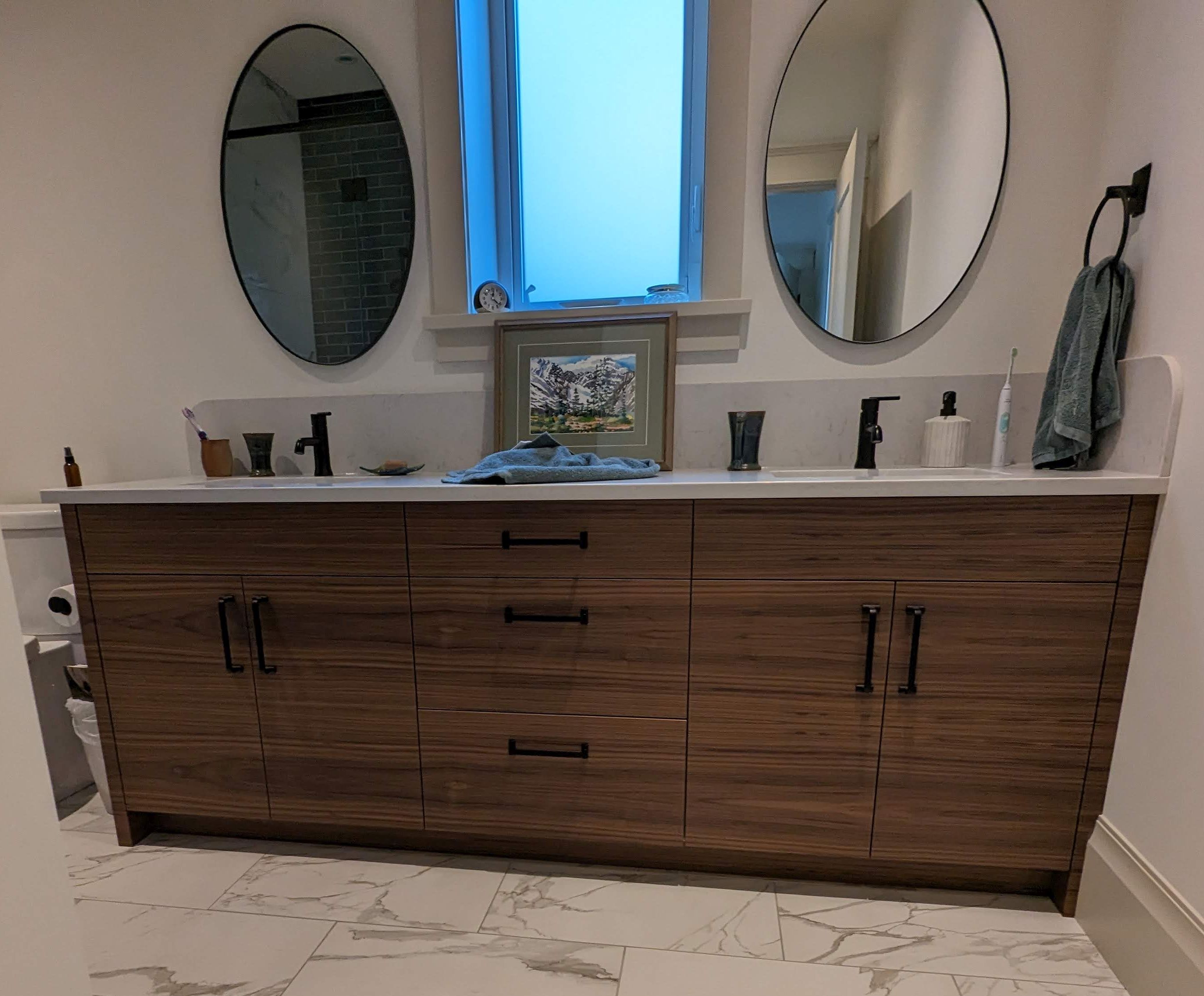 Walnut vanity with grain matched faces and dual sinks.