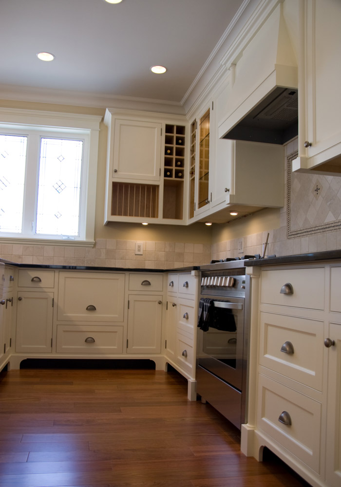 Face-frame kitchen with integrated wine rack, glass cabinets, and professional range