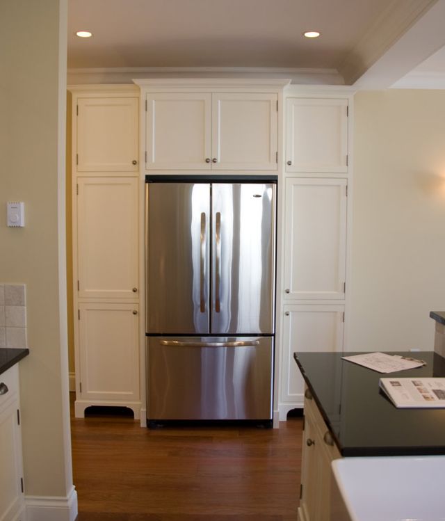 Purpose built fridge enclosure with pantry cabinets on either side.