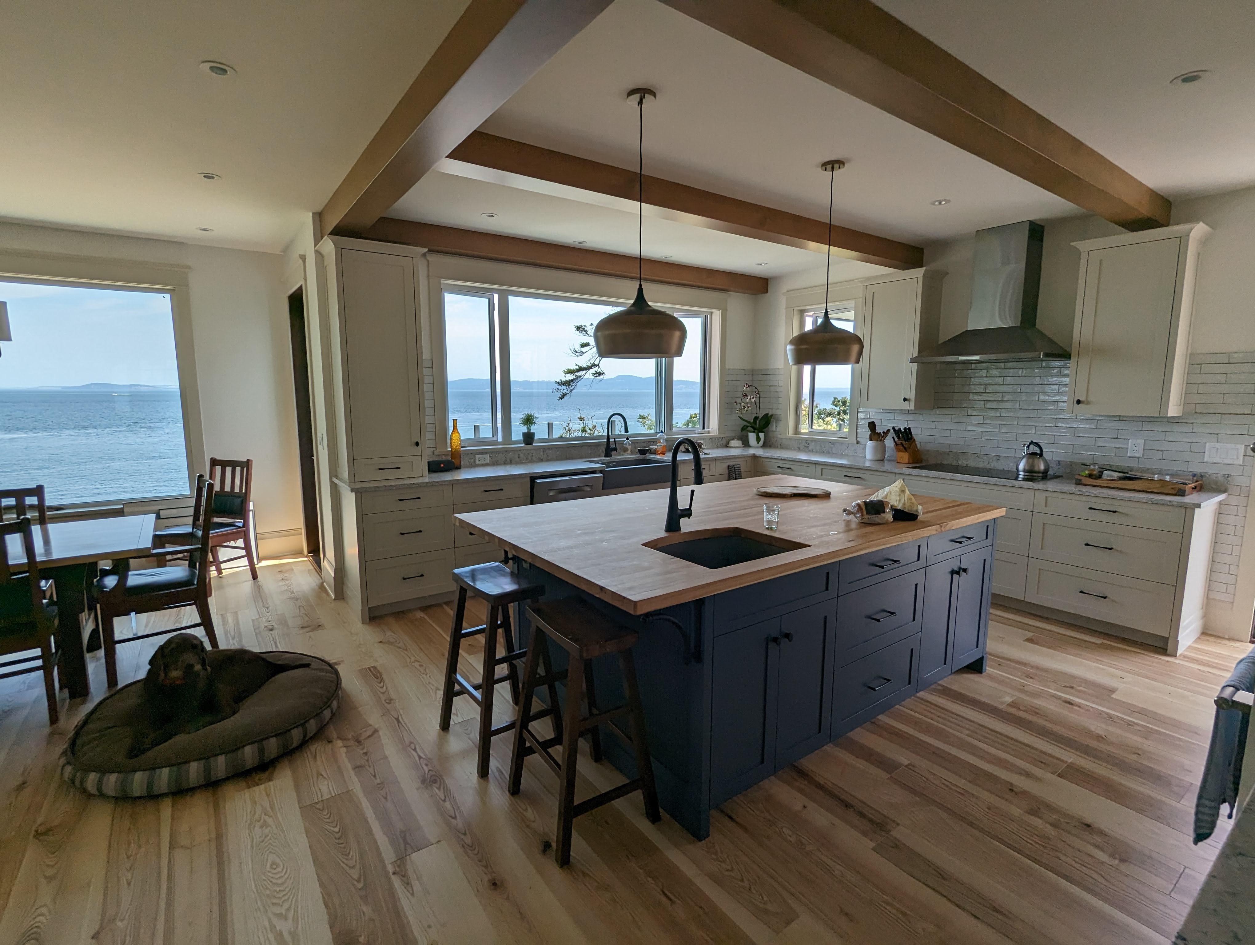 Bright ocean front kitchen with crisp white and blue cabinets and a large butcherblock island counter. 