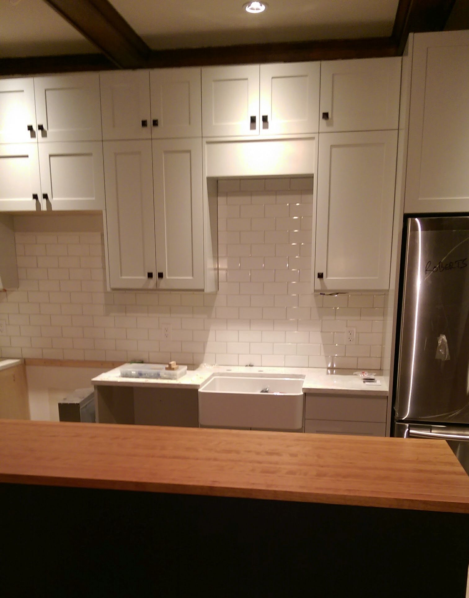 Full-height wall of white shaker cabinets offer clean lines.